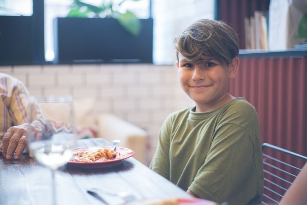 Child enjoying a family meal at a restaurant during a kids-eat-free night