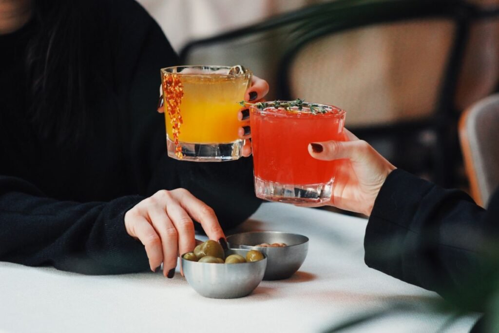 Friends enjoying discounted drinks during a restaurant's happy hour, one of the easiest restaurant deals to find while traveling
