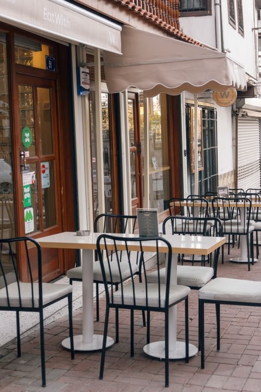 Outdoor cafe seating on a quiet local street, away from the busiest tourist restaurants