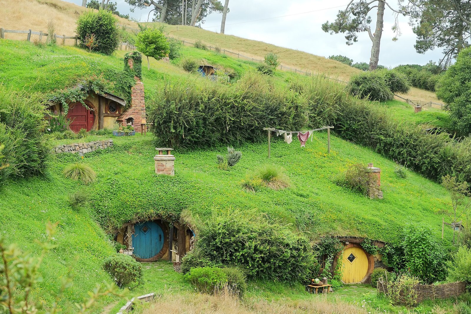 Round hobbit hole doors set into a green hillside at the Hobbiton Movie Set in Matamata, New Zealand