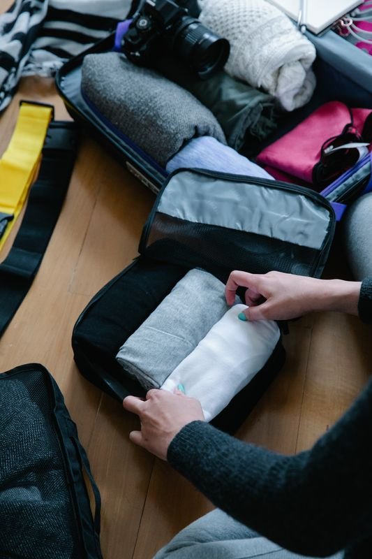 Folding clothes into a packing cube for an organized suitcase