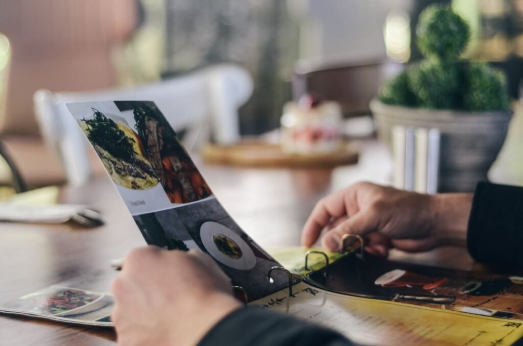 Person reviewing a restaurant menu and prices before deciding where to eat