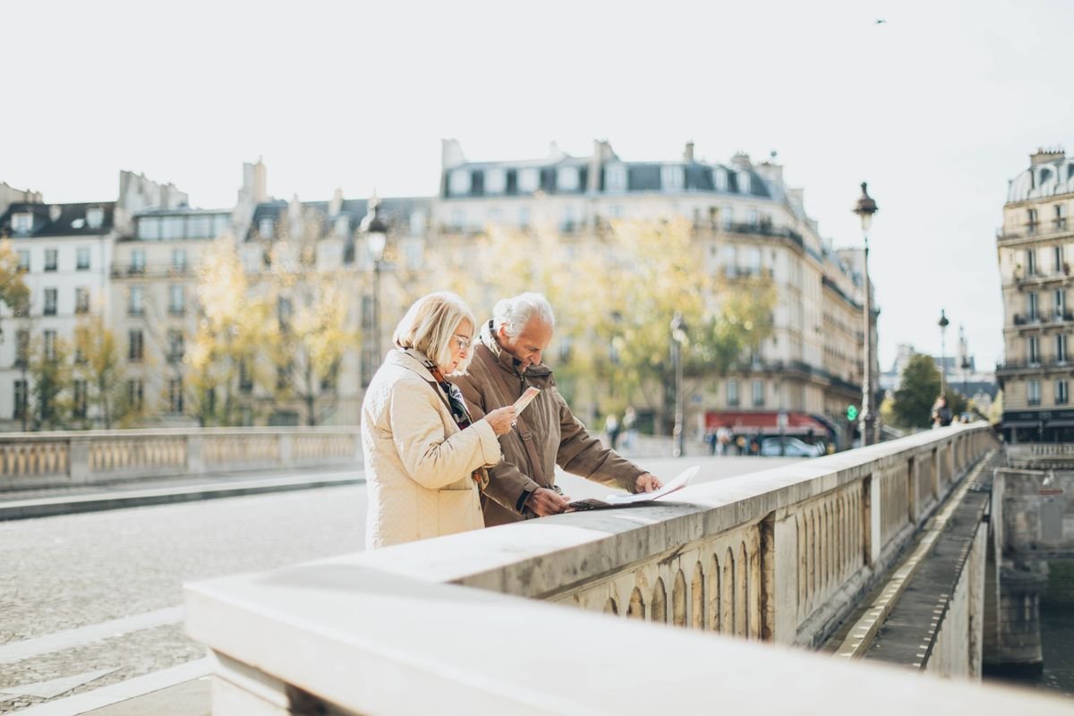 Elderly couple using a map in a scenic European city