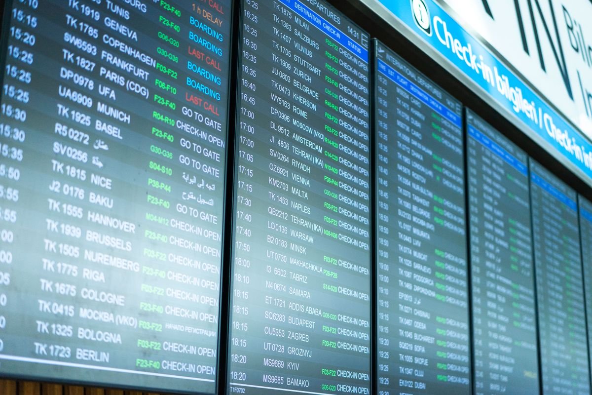 Digital screens displaying flight schedules and delays at an airport terminal