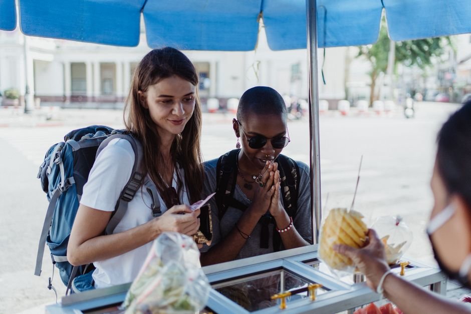Travelers trying local street food, the kind of spot our dining guide highlights