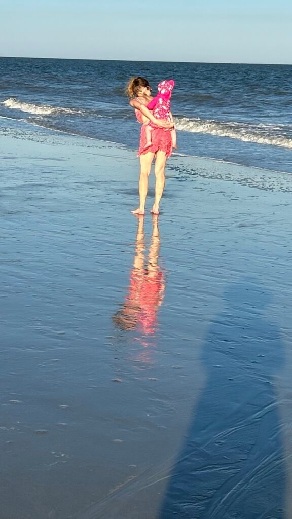 Grandmother and granddaughter walking along the beach at Hilton Head
